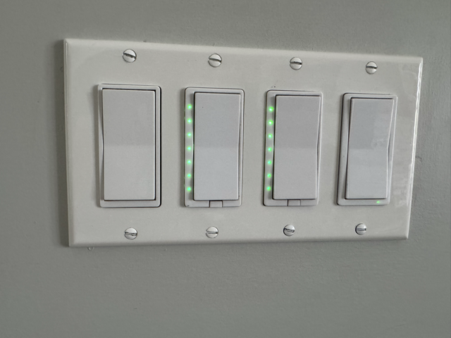 Four HomeSeer HS-WD200+ Z-Wave switches with green status LEDs lit for waste collection reminder in Home Assistant