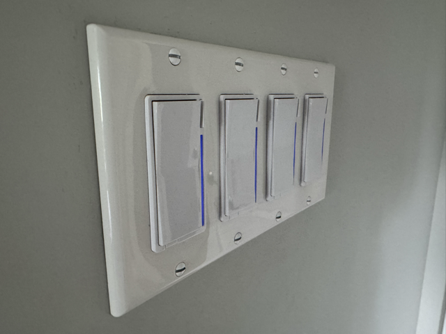 Four Inovelli VZW31-SN Z-Wave switches with blue LED bars lit as a Home Assistant notification alert