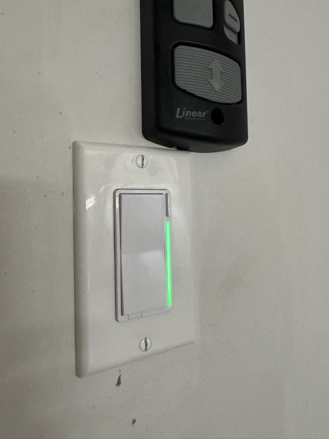 Inovelli VZW31-SN Z-Wave switch in garage with green LED bar lit for waste collection reminder in Home Assistant